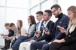 © ASDF - group of young business people with smartphones sitting in a row.