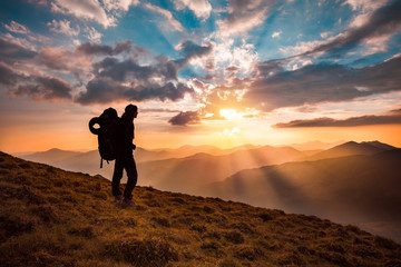 hiking trough epic mountain landscape with a big backpack, exploring and feeling the freedom of natu