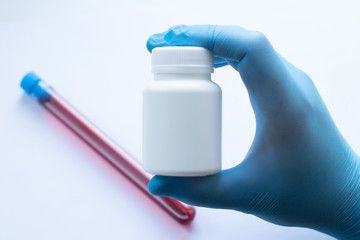 Wall Mural - Doctor in disposable latex gloves holds a jar of antiviral drugs.