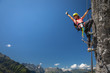 © lightpoet - Pretty, female climber on a via ferrata - climbing on a rock in Swiss Alps