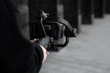 © Volodymyr - Professional videographer in black hoodie holding professional camera on 3-axis gimbal stabilizer. Filmmaker making a great video with a professional cinema camera. Cinematographer.
