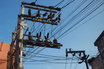 Electric poles with wires on the street against the blue sky.