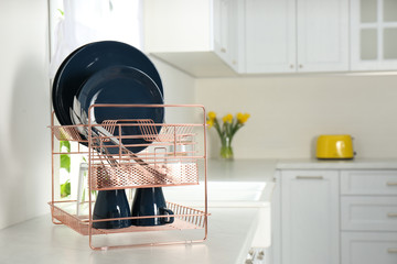 Poster - Drying rack with clean dishes on countertop in kitchen. Space for text