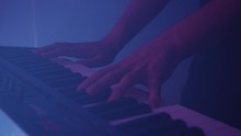 Shot Of Man's Hands Playing Key, Purple Light