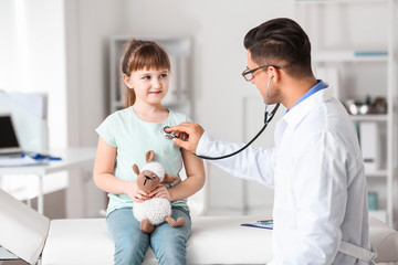 pediatrician examining little girl in clinic
