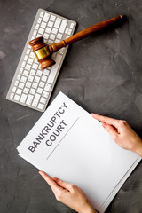 Wall Mural - Bankruptcy court concept with document in hands and gavel on grey background top-down