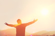 © tonktiti - Copy space of man rise hand up on top of mountain and sunset sky abstract background.