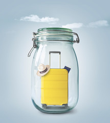 Wall Mural - Tourist yellow suitcase in a glass jar