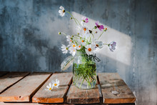 Beautiful Bouquets Of Wildflowers On A Wooden Table On A Cold Concrete Wall Background.