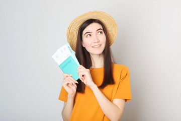 Beautiful young smiling girl holds tickets for travel. Rest, travel, tour.