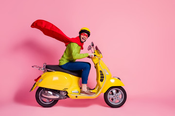 Wall Mural - Profile side view of his he nice attractive crazy overjoyed cheerful cheery guy driving moped fast speed wearing cape rescue safe planet isolated over pink pastel color background