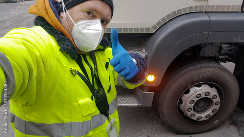 Fotomural young transporter on the truck with face mask and protective gloves for Coronavi