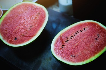 A haft of fresh sweet red watermelon on dark rustic table. summer fresh fruit in Thailand