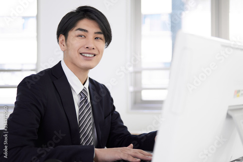 笑顔でパソコン作業をする日本人男性ビジネスマン Stock Photo Adobe Stock