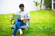 © NVB Stocker - handsome young businessman relaxing and working on laptop computer on lawn at home. Work from home and social distancing concept