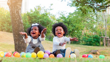 Two Adorable African Boy And Girl Laughing With Happiness When Colorful Balls Coming Down To Them.