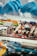 Selective Focus Of Computer Motherboard Near Engineer In Rubber Gloves