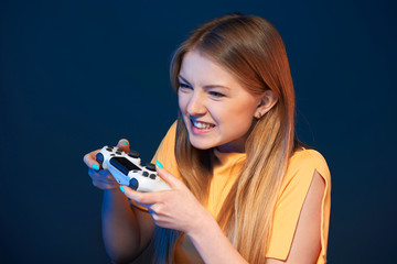 Wall Mural - Emotional girl playing video game with joystick