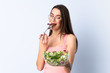 © luismolinero - Young woman with salad over isolated wall