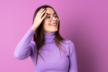 Wall Mural - Young woman over isolated purple background smiling a lot