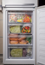 Opened Freezer Refrigerator With Frozen Vegetables And Meat. Freezed Food Supplies Crisis, Food Stock For Quarantine Isolation Period.
