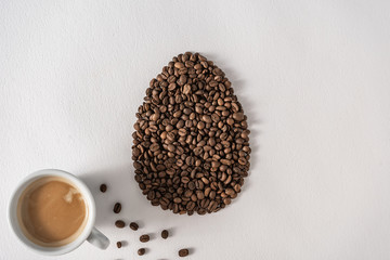 Wall Mural - Creative flat lay composition with easter egg shape made of coffee roasted beans.Pastel colors and soft shadows. Realistic aesthetic look. Contemporary style.