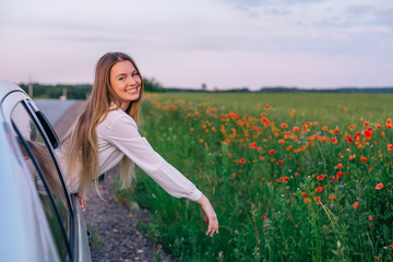 Wall Mural - girl in a white dress looks out of the car window and looks into