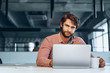 © fotofabrika - Puzzled thoughtful businessman sitting at his working table in an office. Business concept