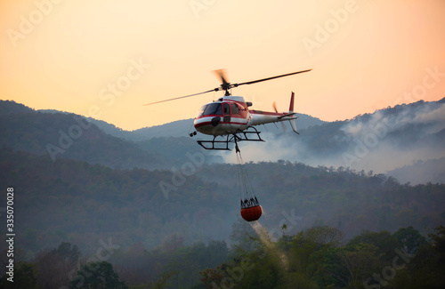 Fotografía The helicopter is drawing water from the reservoir and will be watered to extinguish the burning forest in the mountains