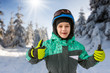 little boy on mountains in ski helmet with fallen first tooth