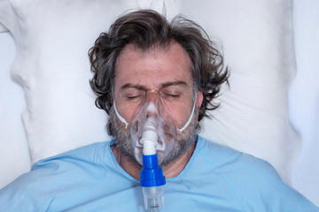 Wall Mural - Aerial portrait of an elderly person, with oxygen mask, in a hospital bed