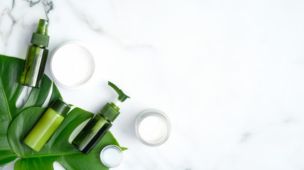 Wall Mural - set of natural organic cosmetics for skincare, body and hair care with tropical leaf on marble backg