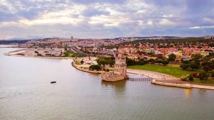 Wall Mural - Lisbon, Portugal. Aerial view of Belem Tower in Lisbon, Portugal during the cloudy day. Time-lapse of famous buildings with a crowd of tourists