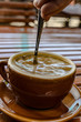 a cup of Hot Americano Coffee with a spoon  on wooden table