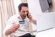 © Teodor Lazarev - Handsome businessman are furious with credit card and mobile.
