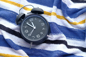 Wall Mural - black vintage alarm clock on towel.