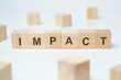 Modern business buzzword - impact. Word on wooden blocks on a white background.