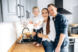 © Kateryna - Happy young family in stylish casual clothes with their adorable baby boy have a good time together at home in the kitchen. They laugh and have fun