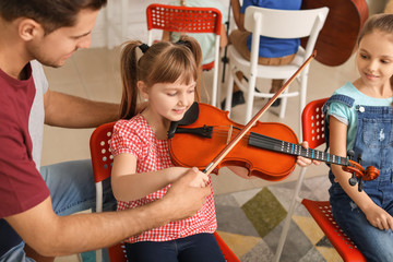 Teacher giving music lessons at school