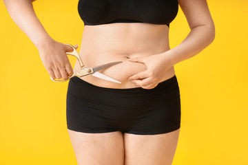 Sticker - Overweight woman with scissors on color background. Weight loss concept