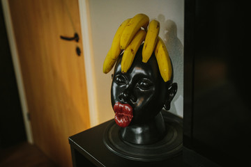 Ripe banana bunch on masks head. banana hair