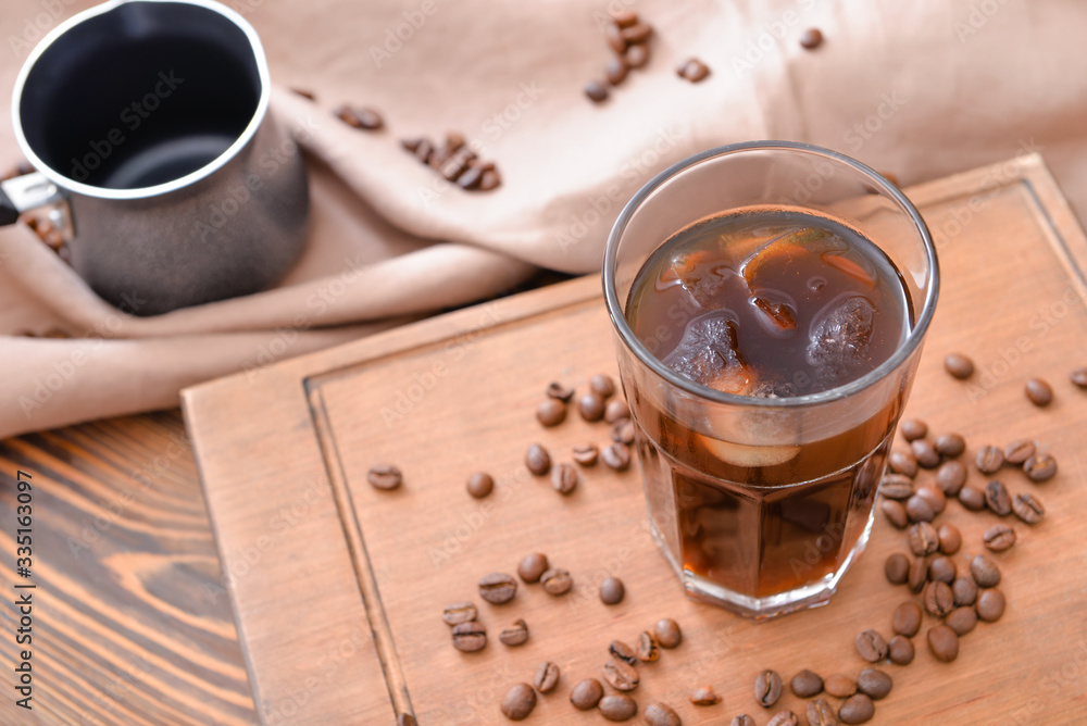 Glass of tasty iced coffee on table
