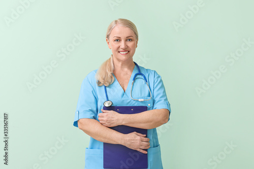 Cuadros en Lienzo Mature female doctor on color background