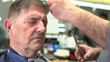 Elderly male getting his haircut at hairdresser.