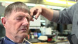 Elderly man getting haircut at barbershop