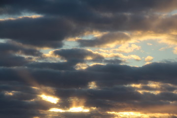 Wall Mural - the suns rays pass through the dark clouds. beautiful dramatic sky at sunset or sunrise.