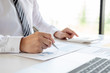 © Orathai - A business man is sitting at a desk and calculating financial graphs about real estate investment expenditures
