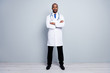 © deagreez - Full body photo of professional family doctor dark skin guy meet patients virologist arms crossed wear white long lab coat neck tie pants shoes isolated grey color background