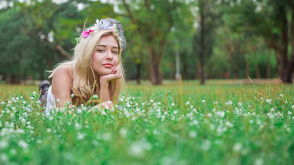 Young girl laying on the grass in spring park and smiling