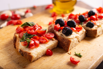 Wall Mural - Mix of bruschette with cherry tomatoes and cream cheese, hummus and black olives. Italian food, healthy appetizer